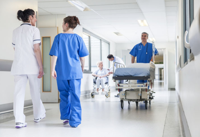 Une personne en train de pousser un brancard dans un couloir d'hôpital
