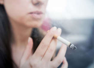 Photographie d'une femme fumant une cigarette