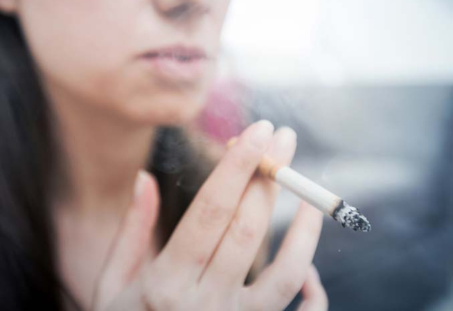 Photographie d'une femme fumant une cigarette